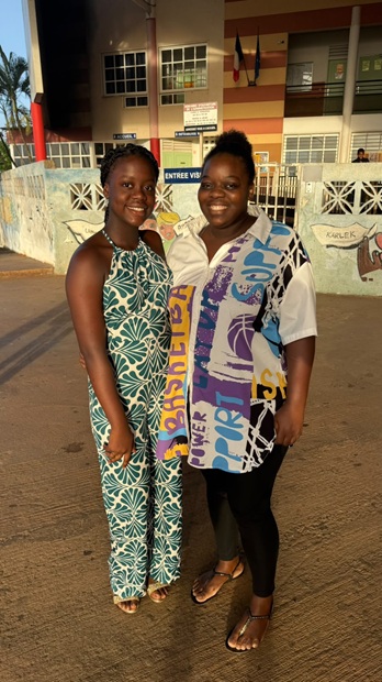 Deux élèves en tenues colorées devant l'entrée du collège