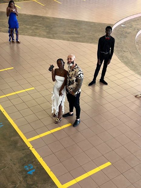 Élève en robe blanche avec un adulte référent