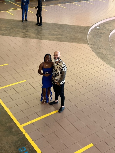 Élève en robe bleue dans la cour avec un adulte