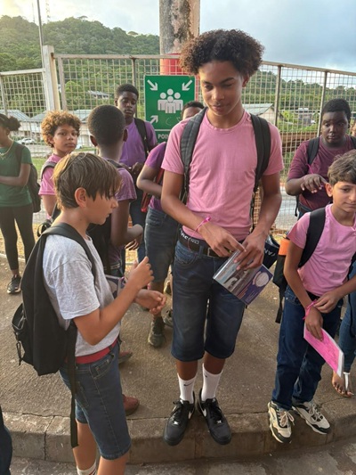 Un élève en tee-shirt rose distribue des rubans à ses camarades